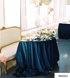 the table is covered with blue cloths and flowers