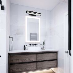 a bathroom with a sink, mirror and lights on the wall above it's counter