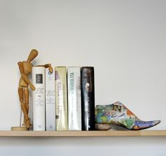 a shelf with books and figurines on it