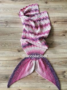 a pink and purple scarf laying on top of a wooden floor