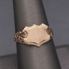 Wonderful Antique Victorian Shield Blank Signet Ring in 14k Gold This wonderful, handsome ring is awaiting its final fate- an engraved set of initials perhaps?  Or a coat of arms seal?  The Victorian ring is stamped 14k on the underside and features a face measuring about 11mm x 9mm, ready to leave as is or engrave.  The shoulders are also fantastic, with deep engravings of a floral pattern, and the band narrows at the base of the shank.  The ring is currently a size 8+ and can be resized before Antique Engraved 14k Gold Ring For Formal Occasions, Formal Engraved 14k Gold Signet Ring, Classic Yellow Gold Engraved Ring With Coat Of Arms, Formal Gold Signet Ring With Coat Of Arms, 14k Gold Timeless Signet Ring Collectible, 14k Gold Timeless Signet Ring For Collectible, Timeless 14k Gold Signet Ring For Collectors, Classic Formal Rings With Coat Of Arms, Formal Engraved Ring With Maker's Mark