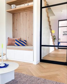 a living room filled with furniture next to a window covered in wooden slatted walls