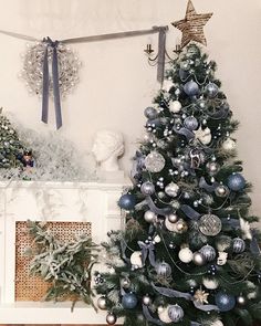 a decorated christmas tree in front of a fireplace