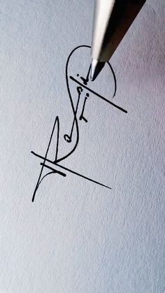 a pen writing on paper with the letter f