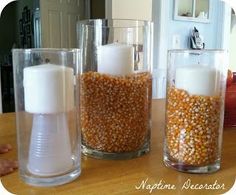 three glass vases with candles in them on a table