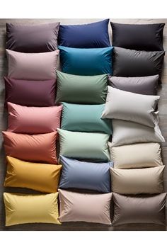 many different colored pillows are arranged in a grid on the wall, and one is empty