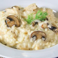 a white plate topped with riso covered in mushrooms and dill sprig