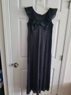 This is a vintage, Gilead night gown. It is sleeveless and has a ruffled portion. It is nylon, made in the usa and floor length. There are some flaws in the material as you can see in the images. The price reflects this. All sales are final. The measurements are as follows: (measurements taken flat and unstretched) Nightgown: Armpit to Armpit: 18 inches Waist: 17.5 inches Hips: 26 inches Length from top of shoulder to middle of hem: 52.5 inches This is a very elegant piece. It is timeless and cl Sleeveless Stretch Nightgown For Spring, Vintage Fitted Ruffle Nightgown, Vintage Fitted Nightgown With Ruffles, Fitted Vintage Nightgown With Ruffles, Daywear Maxi Dress With Ruffles, Black Sleeveless Maxi Dress For Loungewear, Ruffled Maxi Dress For Daywear, Party Sleeveless Nightgown With Lace Trim, Sleeveless Party Nightgown With Lace Trim