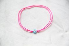 Lucky bracelet, evil eye bracelet, neon string bracelet with evil eye bead, friendship bracelet, pull-tie bracelet, neon pink string bracelet, evil eye protection bracelet, beach jewelry, lucky evil eye bracelet. This bracelet is adjustable size, handmade with handmade  evil eye glass beads and nylon cord string.This one is with neonpink string and the evil eye bead of your choice. You can also have neon yellow or royal blue string with the bead you chose. Hav a look on my others items.You can h Adjustable Pink Evil Eye Bracelet, Pink Summer Friendship Bracelets With Sliding Knot, Cute Pink Friendship Bracelets For Festivals, Pink Sliding Knot Bracelet For Summer, Cute Pink Festival Friendship Bracelets, Evil Eye String Bracelet, Bead Friendship Bracelet, Neon Bracelets, Lucky Charm Bracelet