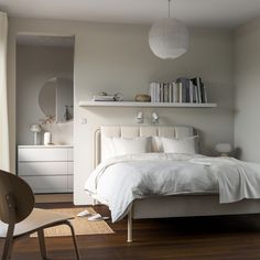 a bedroom with white bedding and wooden floors