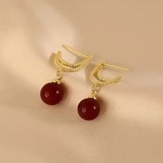 Elevate your style with these stunning red pearl dangle earrings from Barbie Brides. The 14K gold-plating and excellent cut cubic zirconia stones make these earrings perfect for any occasion - from engagements and weddings to birthdays and Valentine's Day. The intricate design and red and gold color combination add a touch of beauty and luck to any outfit, while the fairytale and fantasy theme brings a touch of whimsy. These earrings are made with nickel-free materials, ensuring that they are safe and comfortable to wear all day long. Elegant Ruby Hoop Earrings For Anniversary, Elegant Red Round Hoop Earrings, Elegant Red Pearl Earrings For Parties, Red Elegant Round Hoop Earrings, Elegant Red Hoop Earrings For Formal Occasions, Elegant Red Dangle Jewelry, Elegant Red Drop Earrings, Red Pearl Drop Jewelry For Anniversary, Elegant Red Pearl Drop Jewelry