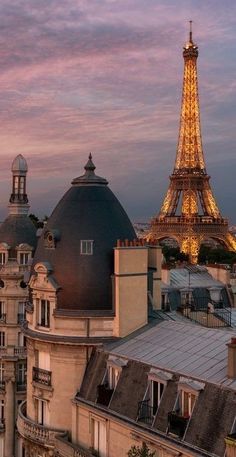 the eiffel tower in paris is lit up at night, with other buildings surrounding it