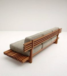 a couch that is sitting on top of a wooden frame with slatted backrests