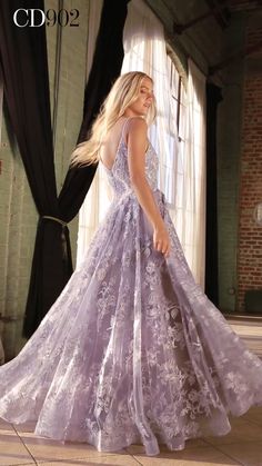 a woman in a long purple dress standing on a tile floor with her back to the camera