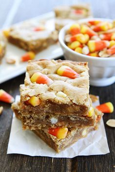 candy corn bars stacked on top of each other in front of a bowl of candy