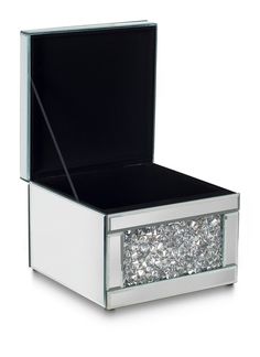 an open white box with lots of silver glitters on the bottom and inside it