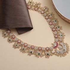 Description A stunning mélange of Mughal motifs from the north with guttapusallu style from southern India, Mahnaz is a handcrafted heirloom necklace, perfect for celebrations. Falling long, the piece features floral nuances and iconic crescents that meet at a lotus bud. Pink and green kempu stones along with uncut polkhis are set in Jadau style, accentuated by a pearl border. Clusters of rice pearls add traditional fervor to this necklace bearing testament to the artistic prowess of our artisan Traditional Long Temple Necklace With Intricate Design, Traditional Jewelry With Intricate Design For Ceremonies, Wedding Long Temple Necklace With Intricate Design, Festive Zari Work Jewelry, Traditional Jewelry For Ceremonies With Intricate Design, Temple Jewelry Necklaces For Eid, Wedding Temple Necklace With Intricate Design, Traditional Intricate Design Necklaces For Eid, Traditional Eid Necklace With Intricate Design