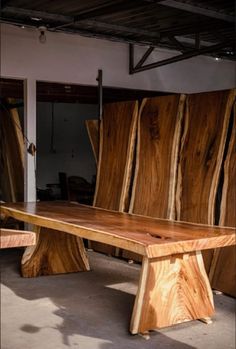 a bench made out of wood sitting inside of a building with no people around it