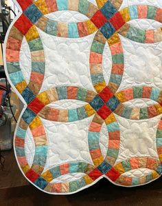 a quilted table topper with multicolored circles on it's sides