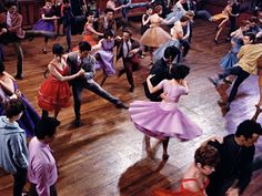 a group of people dancing on a wooden floor