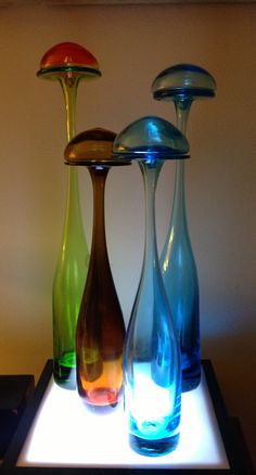 three different colored vases sitting on top of a table