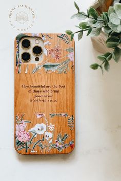 a wooden phone case with an image of flowers on it and the bible verse below