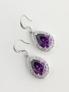 I've created these gorgeous purple amethyst cubic zirconia bridal tear drop dangle earrings in rhodium plated brass setting. Earrings feature a large teardrop with pear cut purple amethyst cubic zirconia center surrounded by tiny round zirconia crystals. Teardrop dangles from a cubic zirconia detailed ear wire. Total length of the earring is 3.8 cms. For matching necklace click: https://www.etsy.com/listing/479272957/amethyst-cubic-zirconia-teardrop-bridal?ref=shop_home_active_19 For matching br Purple Crystal Earrings For Wedding, Elegant Purple Jewelry With Ear Wire, Purple Earrings With Ear Wire For Anniversary, Purple Hook Earrings For Anniversary, Purple Bridal Earrings With Matching Set, Purple Anniversary Earrings With Ear Wire, Purple Pierced Earrings For Wedding, Purple Cubic Zirconia Earrings For Pierced Ears, Purple Sterling Silver Earrings For Party