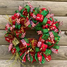 a christmas wreath with candy canes and bows on a wooden wall next to a door