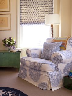 a living room filled with furniture and a window covered in shades on the windowsill