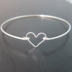 Sterling Silver Heart Bangle Bracelet - A sterling silver heart charm has been transformed into a dainty & delicate heart bracelet with a sterling silver bangle band for you to wear or gift. This is the perfectly dainty heart bracelet for a Valentine's Day gift. Or if you need bridesmaid wedding jewelry and have been looking for sterling silver heart bracelets for bridesmaids, these make for cute bridesmaid gift bracelets. This sterling silver heart jewelry looks great together with others f Bracelets For Bridesmaids, Bridesmaid Gift Bracelet, Cute Bridesmaids Gifts, Silver Heart Jewelry, Bridesmaid Bracelet Gift, Sterling Silver Heart Bracelet, Heart Bangle Bracelet, Silver Heart Bracelet, Gift Bracelet