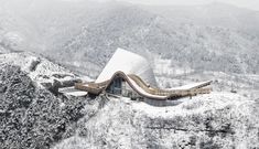 an architecturally designed building on top of a snowy mountain