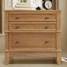 a wooden dresser sitting in front of a window with a clock on top of it