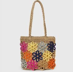 a multicolored crocheted bag with flowers on the front and bottom, hanging from a rope