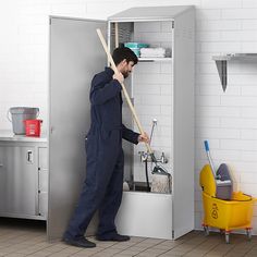 a man with a broom and mop is cleaning the floor in front of a cabinet