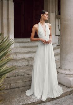 a woman in a white dress standing on some steps