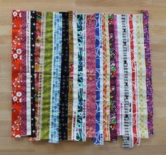 several strips of colorful fabric laid on top of each other in different sizes and colors