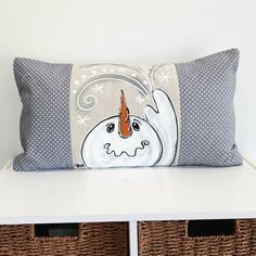 a decorative pillow with an orange carrot on it sitting on top of a white shelf