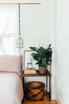 a bed room with a plant on top of it and a shelf next to the bed