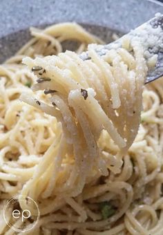 a spoon full of pasta with parmesan cheese on top