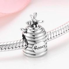 This Sterling Silver Honey Pot Charm is the perfect addition to any jewelry collection. Crafted with 925-grade sterling silver, this charm is an ideal way to show off your love. Show off your unique style with this charmingly detailed charm. Compatible With: Bolenvi Bead Charm Bracelets Bolenvi Moments O Pendants Bolenvi Bead Charm Necklaces Also Compatible: Pandora, Biagi, Troll, Chamilia, Persona, Ohm, Kay's Charmed Memories and similar European Style bead charm bracelets and jewelry. Metal: S Sterling Silver Dangling Charms As Gift, Personalized Silver Charm Bracelet For Her, Personalized Silver Charm Bracelet As Gift For Her, Silver Jewelry With Dangling Charms As A Gift, White Gold Sterling Silver Charms With Dangling Details, White Gold Charms With Dangling Details For Gifts, White Gold Dangling Charms For Gifts, Elegant Sterling Silver Charms For Jewelry Making, Engraved Sterling Silver Symbolic Charms