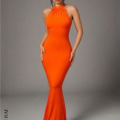 a woman in an orange dress posing for the camera with her hands on her hips