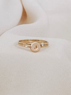 The beautiful initial ring with your birthstone, it's a stunning set of rings, you won’t take off. Personalized by hand with your favorite initial and the beautiful birthstone. A successful ring with a texture that creates its unique shine. This initial ring can be combined with our dainty rings to perfection with our most delicate stackable rings. It also looks minimal and effortless worn alone. * CZ Stone Options: Jan - Garnet Feb - Amethyst Mar - Aquamarine Apr - Diamond May - Emerald Jun - L Personalized Dainty Initial Ring, Dainty Personalized Initial Ring With Round Band, 14k Gold Stackable Rings With Initials, Dainty Personalized Initial Ring, Stackable Rose Gold Initial Ring Open Design, Stackable Rose Gold Initial Open Ring, Stackable Open Initial Ring In Rose Gold, Dainty Stackable Rings With Initials For Promise, Adjustable Rose Gold Dainty Signet Ring