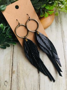 Black feather fringe bling feather ring earring/leather fringe earring/feather earring/fringe earring/bronze black earring/long feather earring So cute and trendy right now! This listing is for one pair of black bling crystal genuine leather feather earrings .Earrings are perfect for just any and everyday wear❤️❤️❤️Antique bronze plated ear wire hooks are nickel and lead Free.Questions , special orders? Please feel free to convo me:) Thanks for taking a look at my shop❤️ Quality products and craftsmanship in all my handmade items. Join my Facebook page to see more handmade jewelry , BellastoneBoutique Leather And Feather Earrings, Adjustable Dangle Feather Jewelry, Black Feathered Jewelry For Party, Adjustable Black Feather Jewelry, Black Feather Jewelry For Party, Bohemian Black Feather Earrings, Party Jewelry With Feather Dangles, Party Feather Dangle Jewelry, Party Jewelry With Dangle Feathers