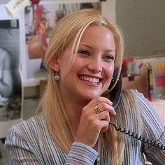 a woman sitting at a desk talking on the phone