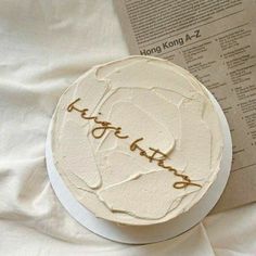 a white cake with writing on it next to a book