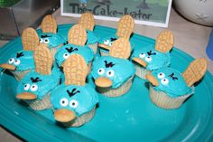 some cupcakes with blue frosting and brown icing are on a plate