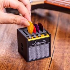 a person is playing with an old fashioned radio on a wooden table next to a guitar