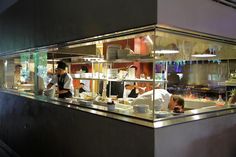 two chefs working behind the counter in a restaurant