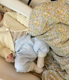 a baby laying in a crib with blankets on top of it's head