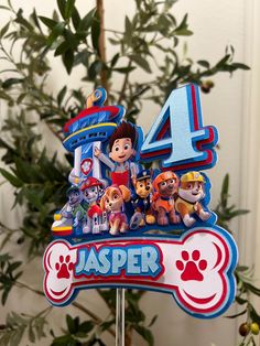 a birthday cake topper with paw patrol characters on it and the number four surrounded by paw patrol figures